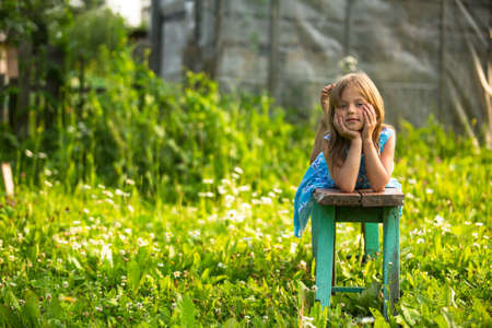 Little girl in the yard of a country houseの写真素材