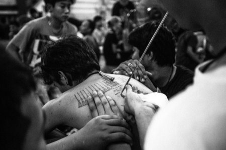 NAKHON CHAI, THAILAND - MAR 23: Unidentified monk makes traditional Yantra tattooing during Wai Kroo Master Day Ceremony (black and white series) on Mar 23, 2013 in Nakhon Chai, Thailand.のeditorial素材
