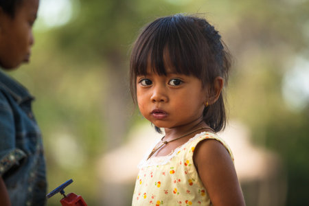 SIEM REAP, CAMBODIA - DEC 13: An unidentified poor child poses for tourists near Angkor Wat, Dec 13, 2012 on Siem Reap, Cambodia. Angkor Wat is the country's prime attraction for visitors. のeditorial素材