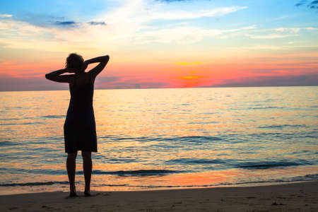 Young woman at the seaside during sunset.の写真素材