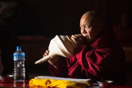 KATHMANDU, NEPAL - DEC 11: Unidentified Buddhist lama play music near stupa Boudhanath Dec 11, 2013 in Kathmandu, Nepal. Stupa is one of the largest in the world, of 1979 is a UNESCO World Heritage Site.のeditorial素材