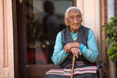 KATHMANDU, NEPAL - NOV 30: Unidentified old woman near Boudhanath, Nov 30, 2013 in Kathmandu, Nepal. Ancient Stupa is one of the largest in the world, of 1979 is a UNESCO World Heritage Site.のeditorial素材