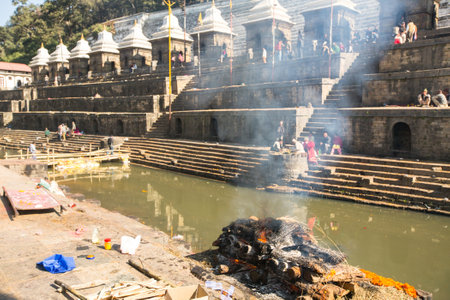 KATHMANDU, NEPAL - DEC 3: During the cremation ceremony along the holy Bagmati River in Bhasmeshvar Ghat at Pashupatinath temple, Dec 3, 2013 in Kathmandu, Nepal.のeditorial素材