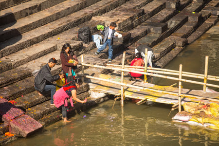KATHMANDU, NEPAL - DEC 3: Unidentified local people during the cremation ceremony along the holy Bagmati River in Bhasmeshvar Ghat at Pashupatinath temple, Dec 3, 2013 in Kathmandu, Nepal.のeditorial素材
