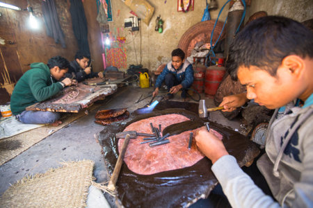 BHAKTAPUR, NEPAL - DEC 5: Unidentified Nepalese tinman working in the his workshop, Dec 5, 2013 in...