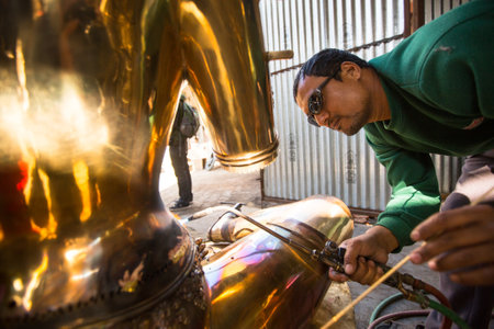 BHAKTAPUR, NEPAL - DEC 5: Unidentified Nepalese tinman working in the his workshop, Dec 5, 2013 in Bhaktapur, Nepal. 100 cultural groups have created an image Bhaktapur as Capital of Nepal Arts.のeditorial素材