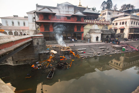 KATHMANDU, NEPAL - DEC 20: During the cremation ceremony along the holy Bagmati River in Bhasmeshvar Ghat at Pashupatinath temple, Dec 20, 2013 in Kathmandu, Nepal.のeditorial素材
