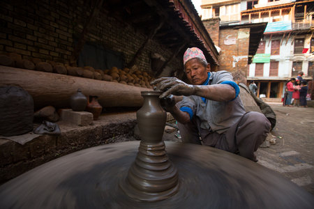 BHAKTAOUR, NEPAL - DEC 7: Unidentified Nepalese man working in the his pottery workshop, Dec 7, 2013 in Bhaktapur, Nepal. 100 cultural groups have created an image Bhaktapur as Capital of Nepal Arts.のeditorial素材