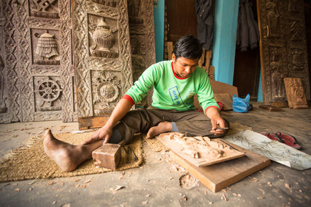 BHAKTAPUR, NEPAL - DEC 19: Unidentified Nepalese man working in the his wood workshop, Dec 19, 2013 in Bhaktapur, Nepal. 100 cultural groups have created an image Bhaktapur as Capital of Nepal Arts.のeditorial素材