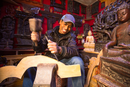 BHAKTAPUR, NEPAL - DEC 19: Unidentified Nepalese man working in the his wood workshop, Dec 19, 2013 in Bhaktapur, Nepal. 100 cultural groups have created an image Bhaktapur as Capital of Nepal Arts.のeditorial素材