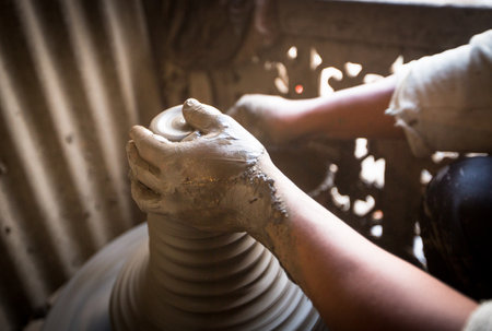 BHAKTAPUR, NEPAL - DEC 7, 2013: Unidentified Nepalese man working in the his pottery workshop. More 100 cultural groups have created an image Bhaktapur as Capital of Nepal Arts.のeditorial素材