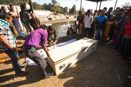 KATHMANDU, NEPAL - DEC 3, 2013: Unidentified local people during the cremation ceremony along the holy Bagmati River in Bhasmeshvar Ghat at Pashupatinath temple in Kathmandu.のeditorial素材