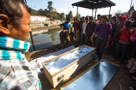 KATHMANDU, NEPAL - DEC 3, 2013: Unidentified local people during the cremation ceremony along the holy Bagmati River in Bhasmeshvar Ghat at Pashupatinath temple in Kathmandu.のeditorial素材
