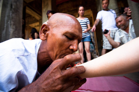 SIEM REAP, CAMBODIA - DEC 13: Hindu Brahmin blesses tourists in one of the temples of Angkor Wat complex, Dec 13, 2012 Siem Reap, Cambodia. It is the country's prime attraction for visitors. のeditorial素材