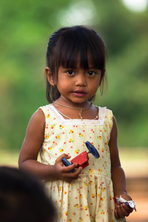 SIEM REAP, CAMBODIA - DEC 13: An unidentified poor child poses for tourists near Angkor Wat, Dec 13, 2012 on Siem Reap, Cambodia. Angkor Wat is the country's prime attraction for visitors.のeditorial素材