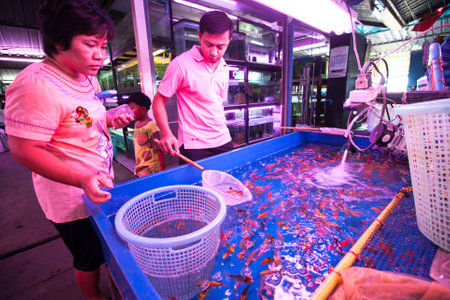 BANGKOK, THAILAND - APRIL 24: Unidentified seller in fishmarket at Chatuchak Weekend Market April 24, 2012 in Bangkok, Thailand. Chatuchak is one of the world's largest markets covering over 35 acres with 15,000 stalls.のeditorial素材