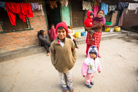 KATHMANDU, NEPAL - DEC 19, 2013: Unidentified local children near their homes in a poor area of the city. The caste system is still intact today but the rules are not as rigid as they were in the past.のeditorial素材