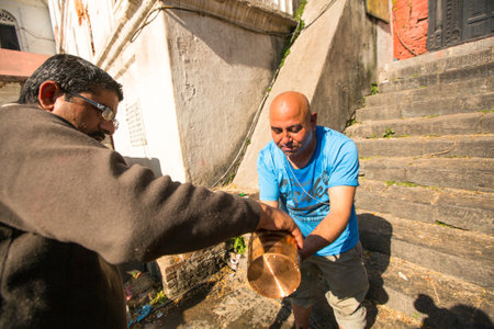 KATHMANDU, NEPAL - DEC 3, 2013: Unidentified local people during the cremation ceremony along the holy Bagmati River in Bhasmeshvar Ghat at Pashupatinath temple in Kathmandu.のeditorial素材