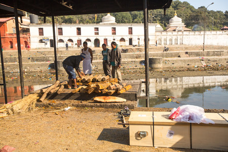 KATHMANDU, NEPAL - DEC 3: Unidentified local people during the cremation ceremony along the holy Bagmati River in Bhasmeshvar Ghat at Pashupatinath temple, Dec 3, 2013 in Kathmandu, Nepal.のeditorial素材