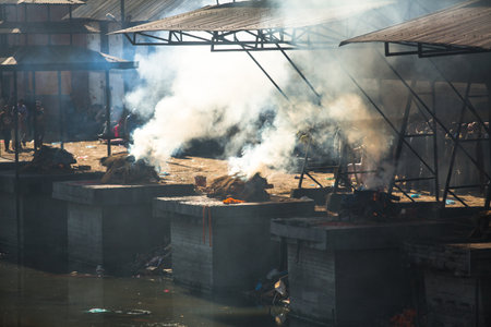 KATHMANDU, NEPAL - DEC 3: During the cremation ceremony along the holy Bagmati River in Bhasmeshvar Ghat at Pashupatinath temple, Dec 3, 2013 in Kathmandu, Nepal.のeditorial素材