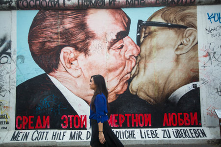 BERLIN, GERMANY - MAY 23, 2014: Fragment of graffiti ("Kiss" by Dmitry Vrubel) on Berlin Wall at East Side Gallery - it's a 1.3 km long part of original Berlin Wall which collapsed in 1989 and now is the largest world graffiti gallery.のeditorial素材