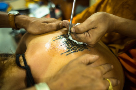 NAKHON CHAI, THAILAND - MAR 1: Unidentified monk makes traditional Yantra tattooing on Mar 1, 2012 in Nakhon Chai, Thailand. Yantra tattoo also called Sak Yant, practiced in Southeast Asian countries.のeditorial素材