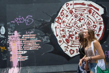 BERLIN, GERMANY - MAY 23, 2014: Fragment of graffiti on Berlin Wall at East Side Gallery - it's a 1.3 km long part of original Berlin Wall which collapsed in 1989 and now is the largest world graffiti gallery.のeditorial素材