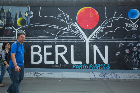 BERLIN, GERMANY - MAY 23, 2014: Fragment of graffiti on Berlin Wall at East Side Gallery - it's a 1.3 km long part of original Berlin Wall which collapsed in 1989 and now is the largest world graffiti gallery.のeditorial素材