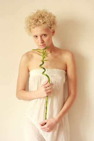 A young girl gently holds in hands green sprout.の写真素材