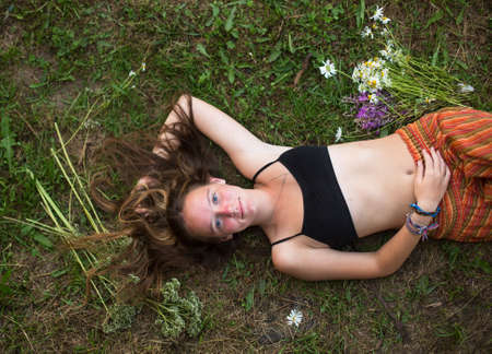 Beautiful young girl lying on the grass, from top.の写真素材