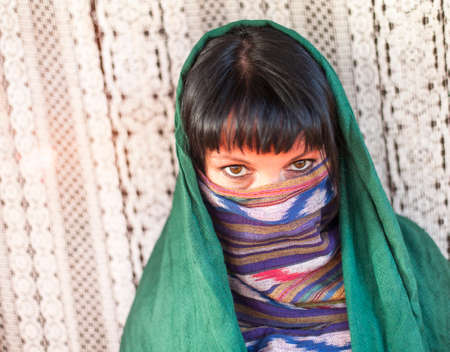 Young girl covers her face with a veil. Hijab. の写真素材