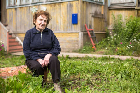 Portrait of old woman near her home.の写真素材