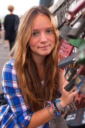 Portrait of pretty young girl on the bridge with locks on bridge of love.の写真素材