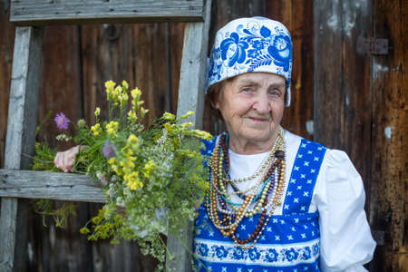 Old woman in russian ethnic clothes, outdoors.の写真素材