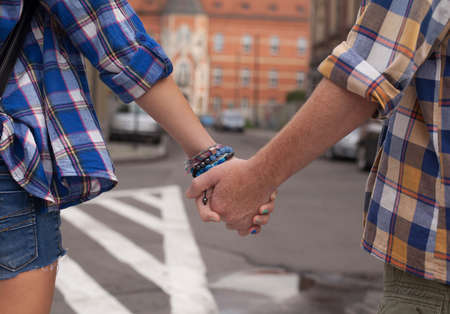 Hands of young couple on the street in Europe, close-up shoot.の写真素材