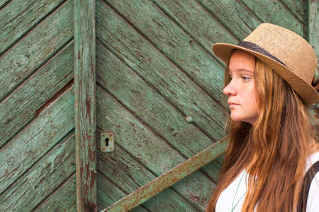 Young pretty girl on a background of old wooden doors.の写真素材
