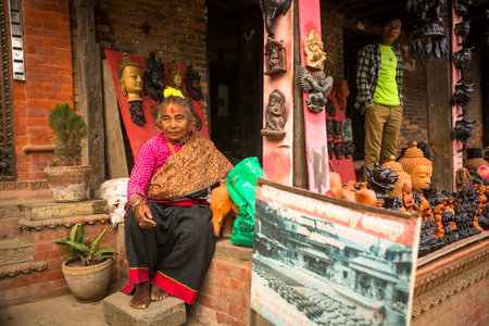 BHAKTAPUR, NEPAL - DEC 7, 2013: Unidentified Nepalese woman in the his pottery workshop. More 100 cultural groups have created an image Bhaktapur as Capital of Nepal Arts.のeditorial素材