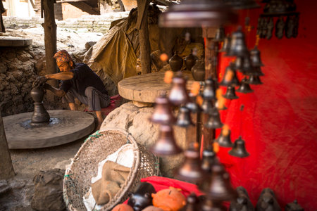 BHAKTAPUR, NEPAL - DEC 7, 2013: Unidentified Nepalese man working in the his pottery workshop. More 100 cultural groups have created an image Bhaktapur as Capital of Nepal Arts.のeditorial素材