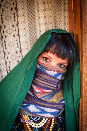 Portrait of young girl covers her face with a veil. Hijab.の写真素材