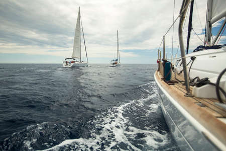 Sailing ship yachts in the sea in cloudy weather.