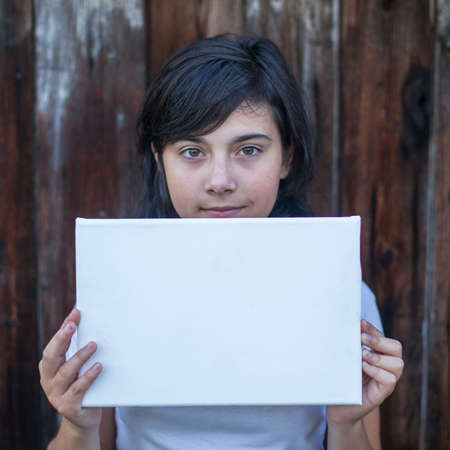 Teen girl with a white banner in the hands (space for your message)の写真素材