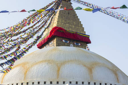 Boudhanath stupa - the symbol of Nepal, with colorful prayer flags in the background.の写真素材