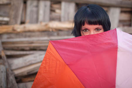 Young woman peeping from behind the umbrella.の写真素材