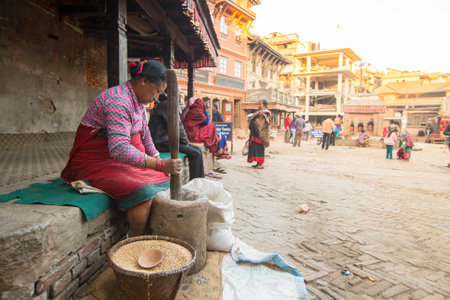 BHAKTAOUR, NEPAL - DEC 7, 2013: Unidentified Nepalese woman working in the his pottery workshop. More 100 cultural groups have created an image Bhaktapur as Capital of Nepal Arts.のeditorial素材