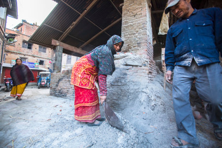 BHAKTAPUR, NEPAL - CIRCA DEC, 2013: Unidentified Nepalese people working in the his pottery workshop. More 100 cultural groups have created an image Bhaktapur as Capital of Nepal Arts.のeditorial素材
