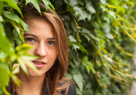 Portrait of a young pretty girl in the Park among the greenery.の写真素材