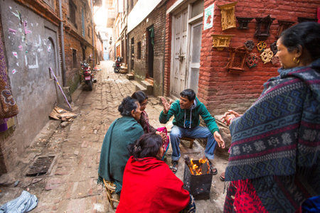 BHAKTAPUR, NEPAL - CIRCA DEC, 2013: Unidentified local people sit in the street. The caste system is still intact today but the rules are not as rigid as they were in the past.のeditorial素材