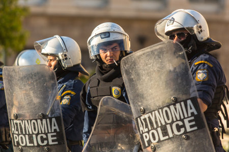 ATHENS, GREECE - APR 16, 2015: Riot police with their shield, take cover during a rally in front of...
