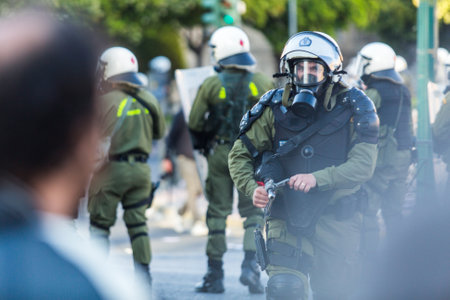 ATHENS, GREECE - APR 16, 2015: Riot police with their shield, take cover during a rally in front of the Athens University, which is under occupation by protesters leftist and anarchist groups.のeditorial素材