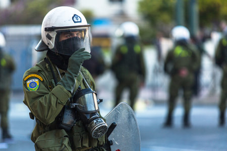 ATHENS, GREECE - APR 16, 2015: Riot police with their shield, take cover during a rally in front of the Athens University, which is under occupation by protesters leftist and anarchist groups.のeditorial素材
